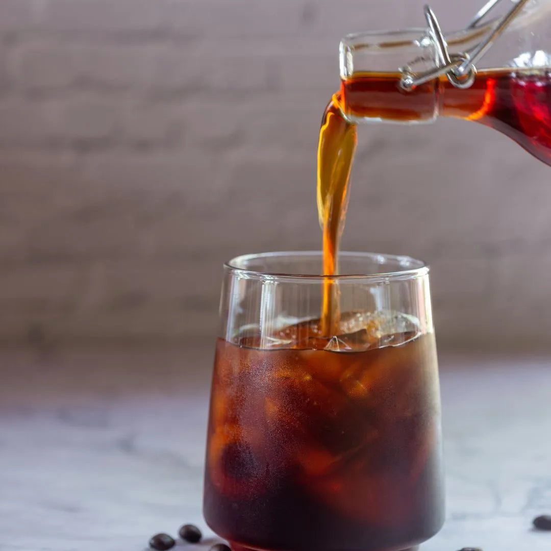 Pouring cold brew coffee to a glass.